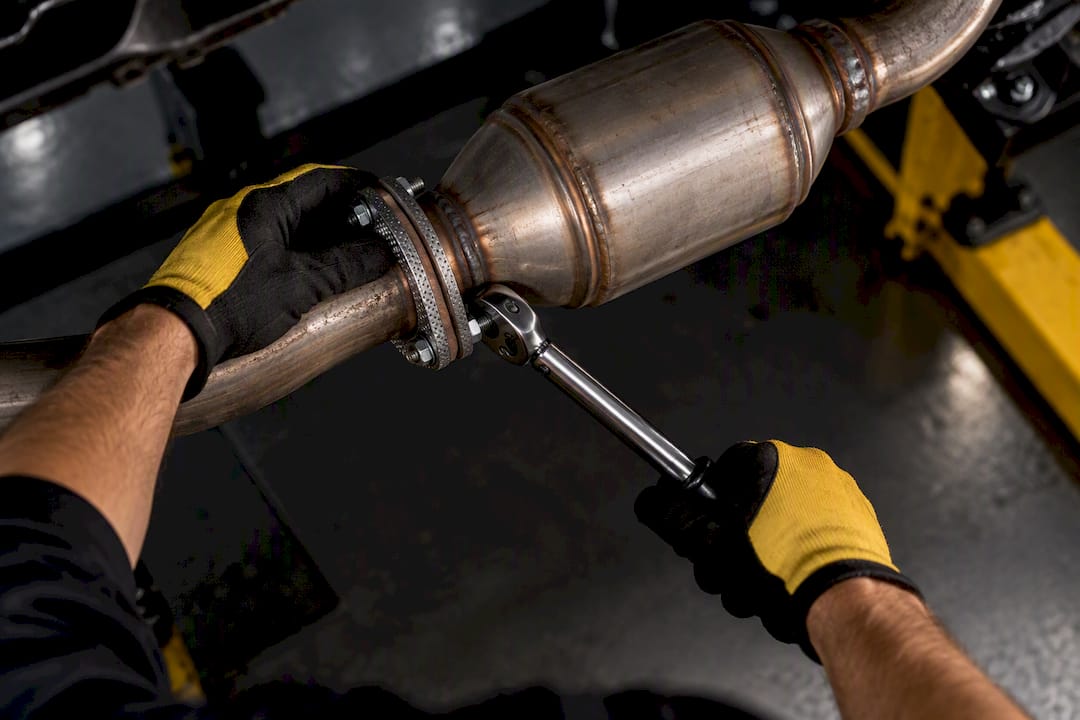 Technician tightening an exhaust flange with new gasket
