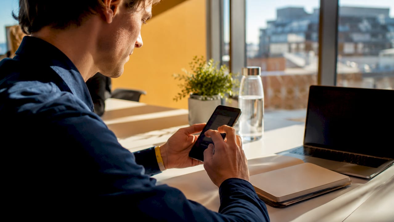 Händer som använder en mobilapp för affärskommunikation