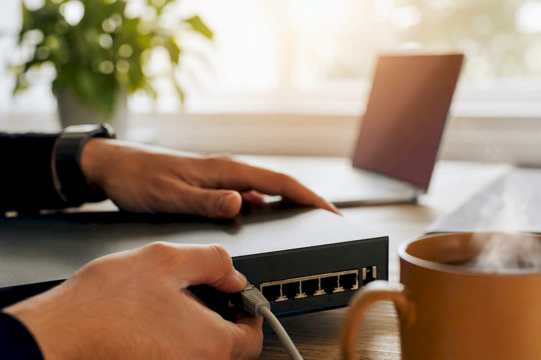 Händer som kopplar in en Ethernet-kabel på kontoret