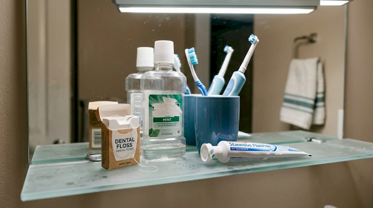 Oral care products on bathroom shelf