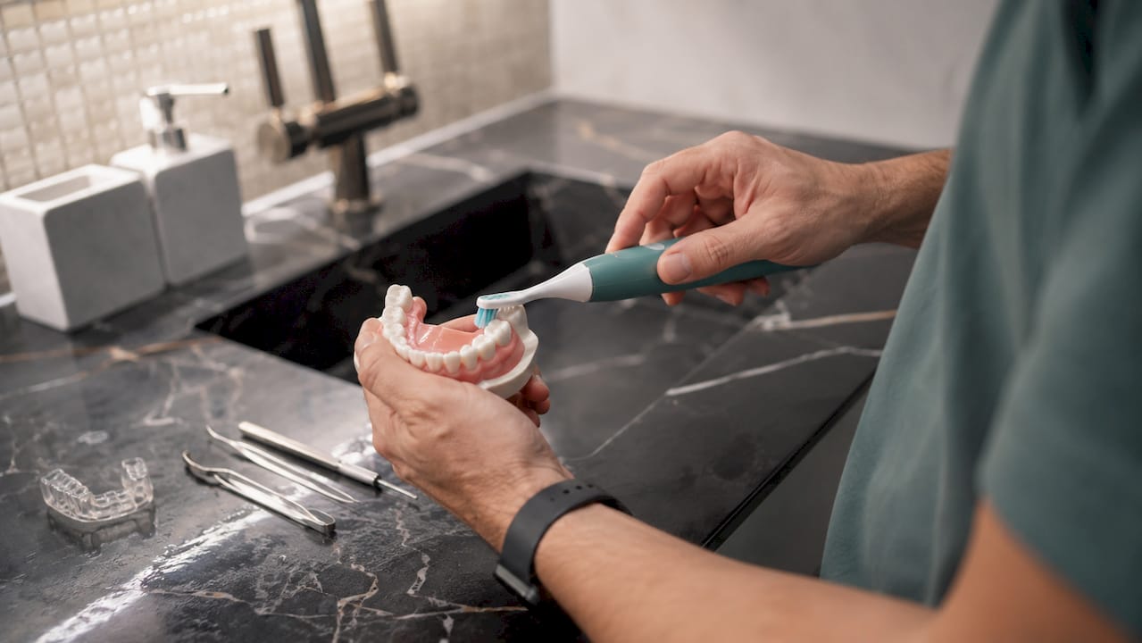 Close-up of automatic toothbrush brushing teeth model