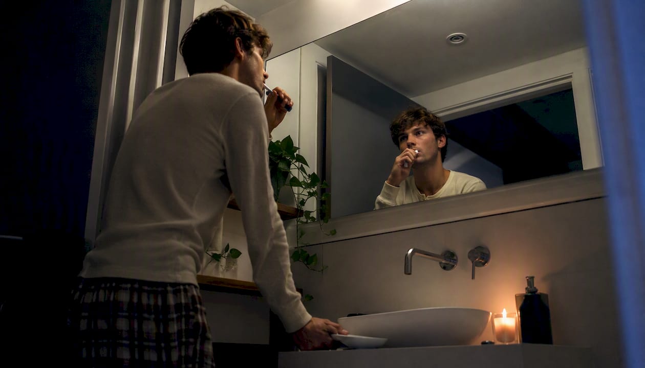 Person brushing teeth before bed in bathroom