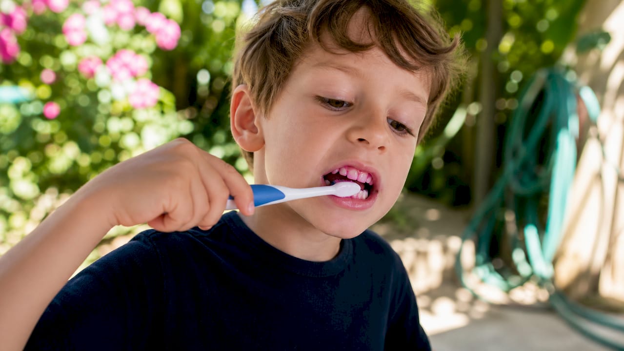 Child brushing stained teeth after using disclosing tablet