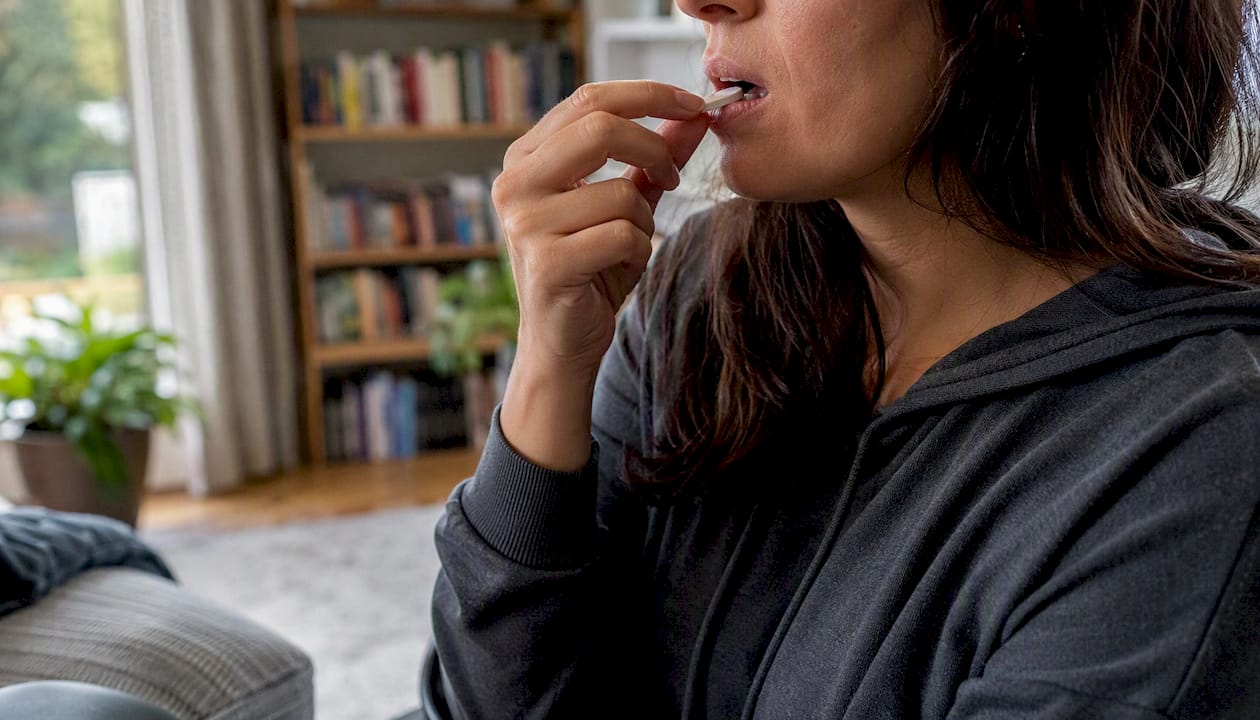 Hand holding chewing gum near mouth