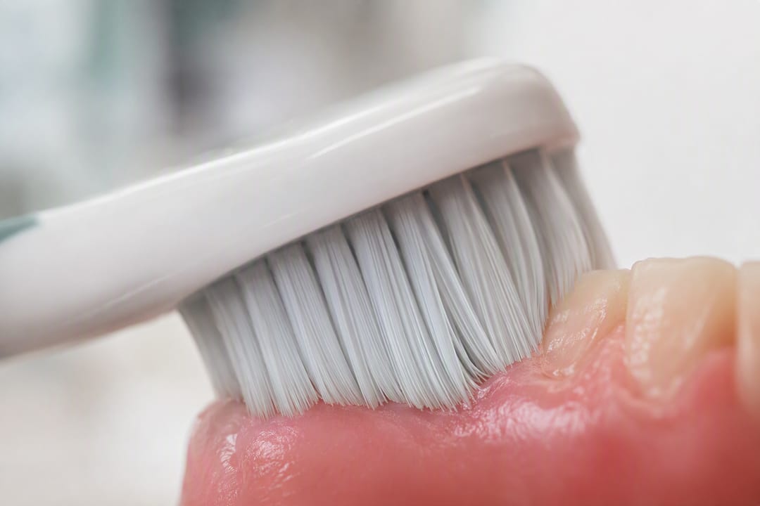 Soft toothbrush head contacting gum tissue