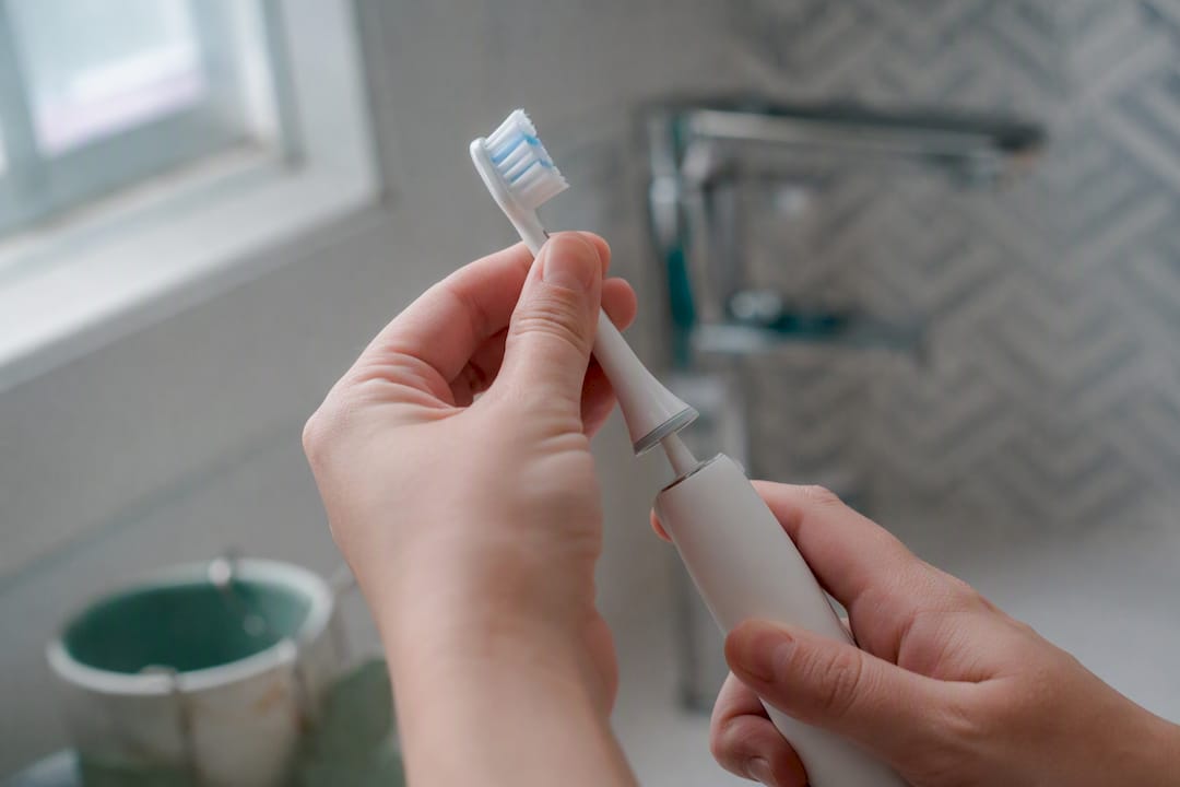 Hand removing worn sonic toothbrush head