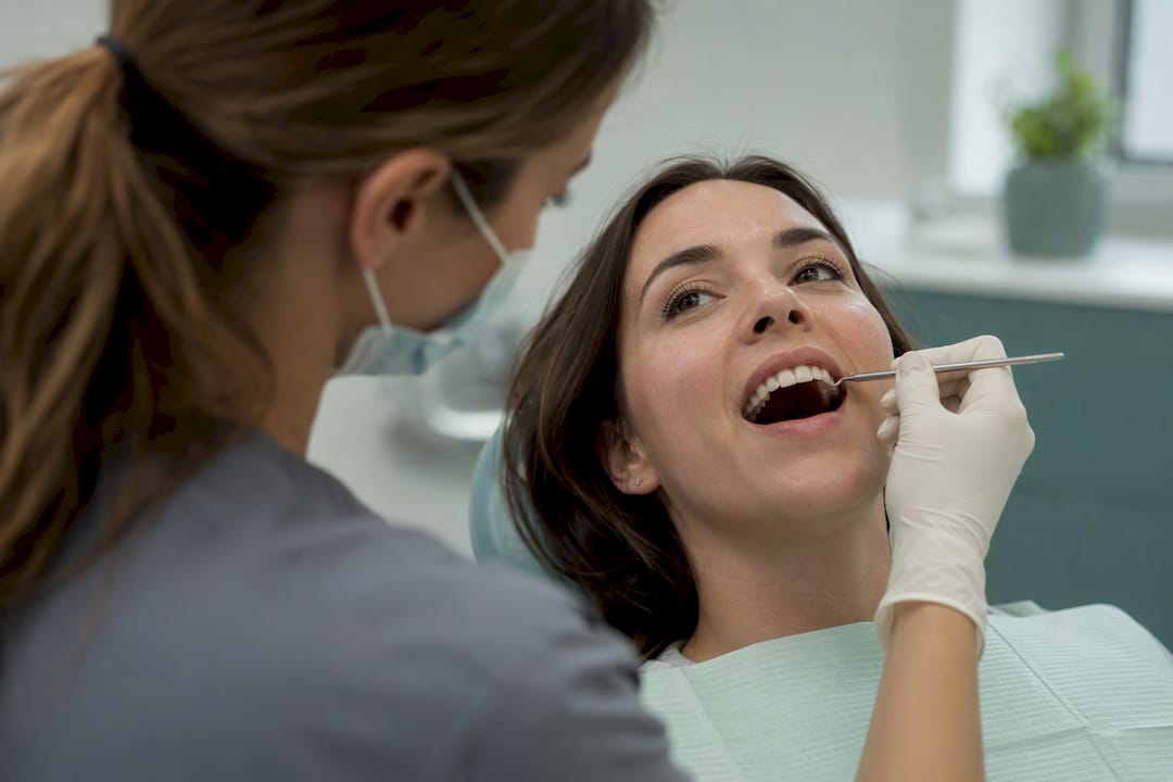 Dental hygienist checking teeth with explorer tool