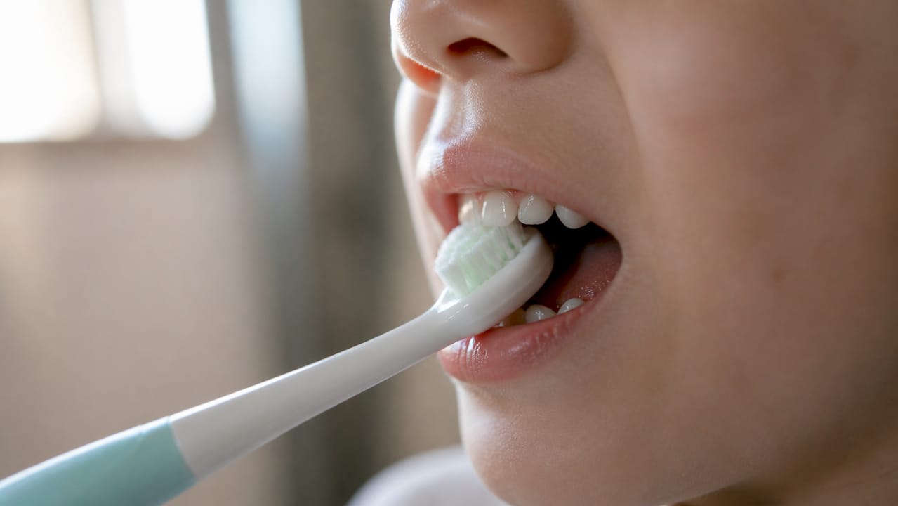 Close-up on toddler's mouth brushing sensitive gums