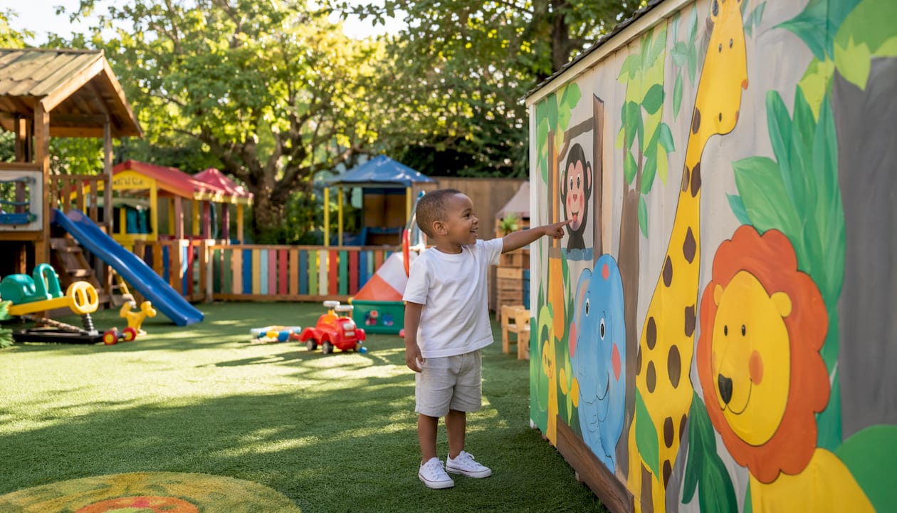 Toddler engaging with child-height sign in classroom