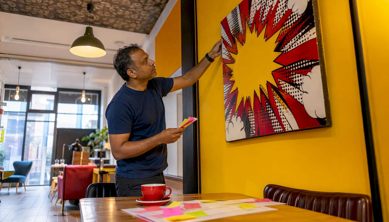 Man adjusting timber artwork in law firm waiting room