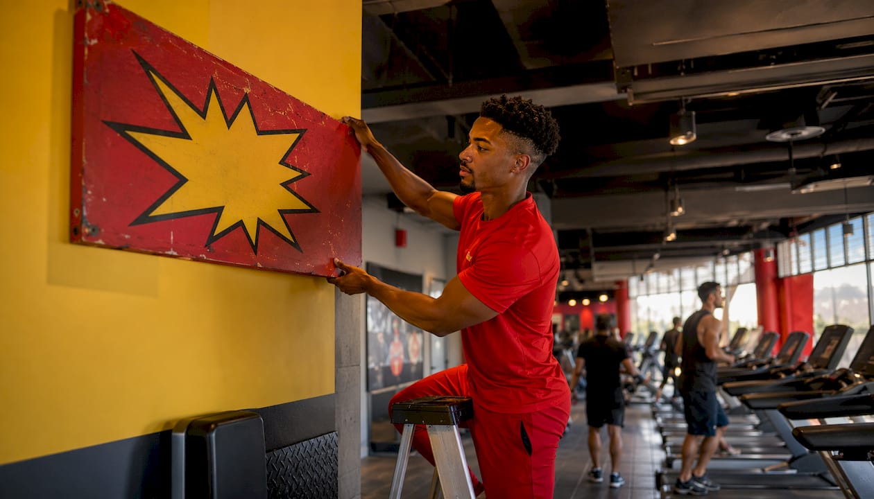 Gym staff mounting free weights area sign