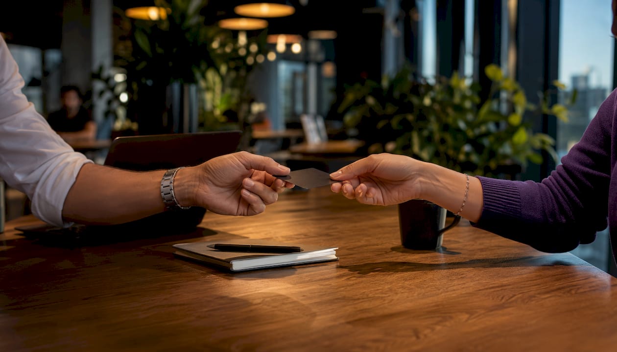 Hands exchanging corporate card at startup desk