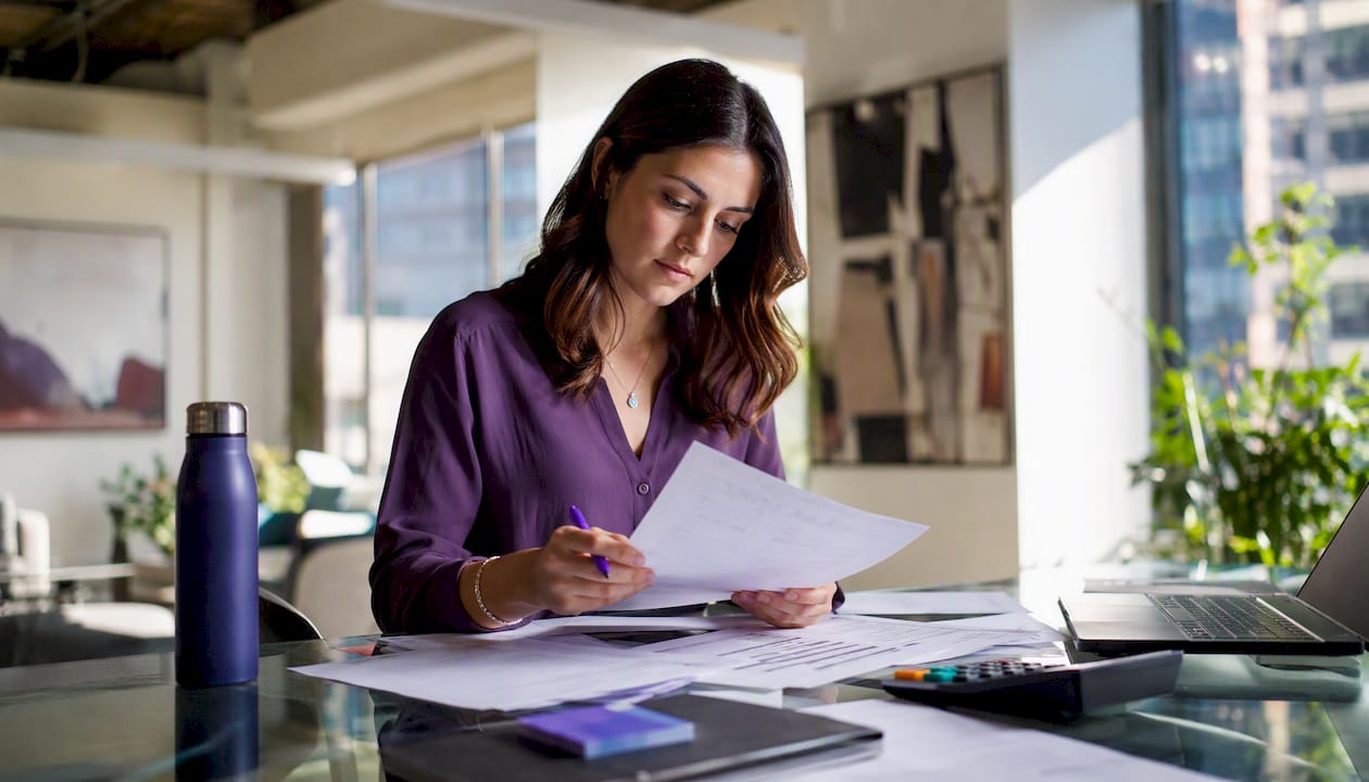 Finance analyst reviewing invoices and spreadsheets