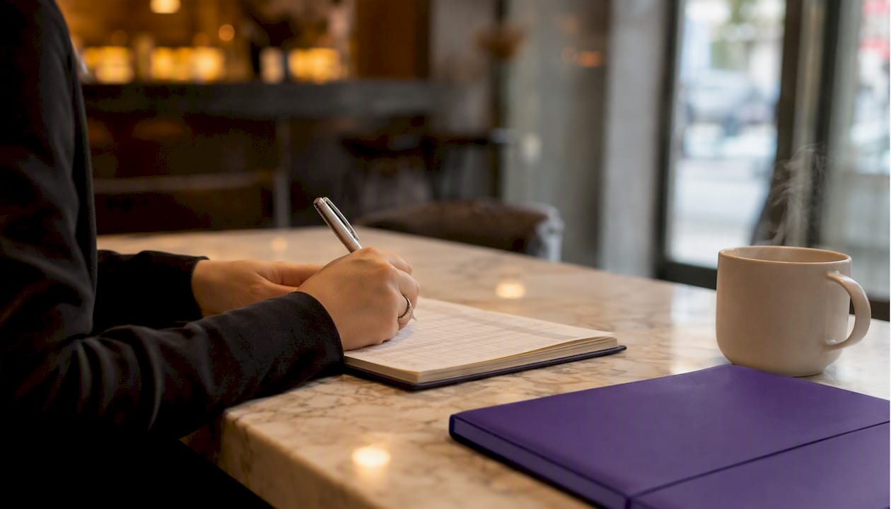 Hands manually numbering invoices on ledger