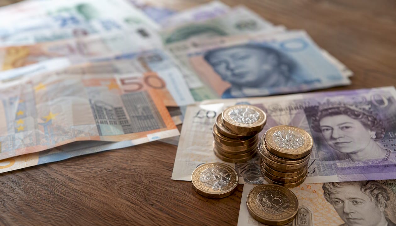 British pound coins next to foreign currency