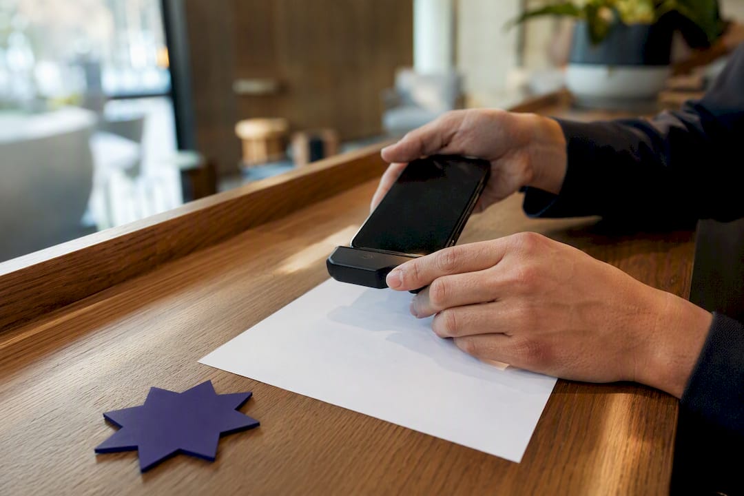 Hands scanning invoice with phone attachment
