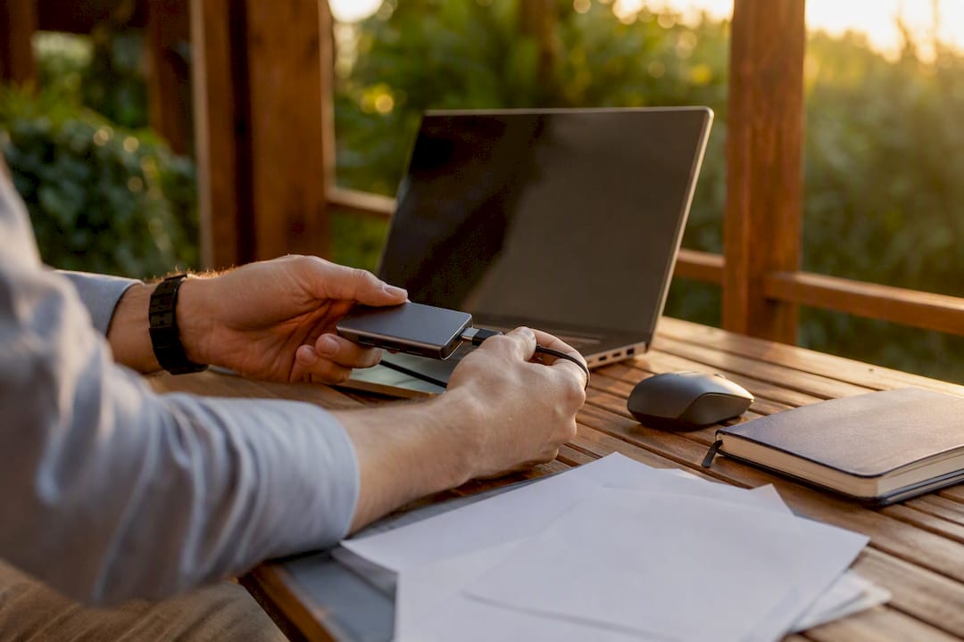 Hands connecting a USB-C hub on startup desk