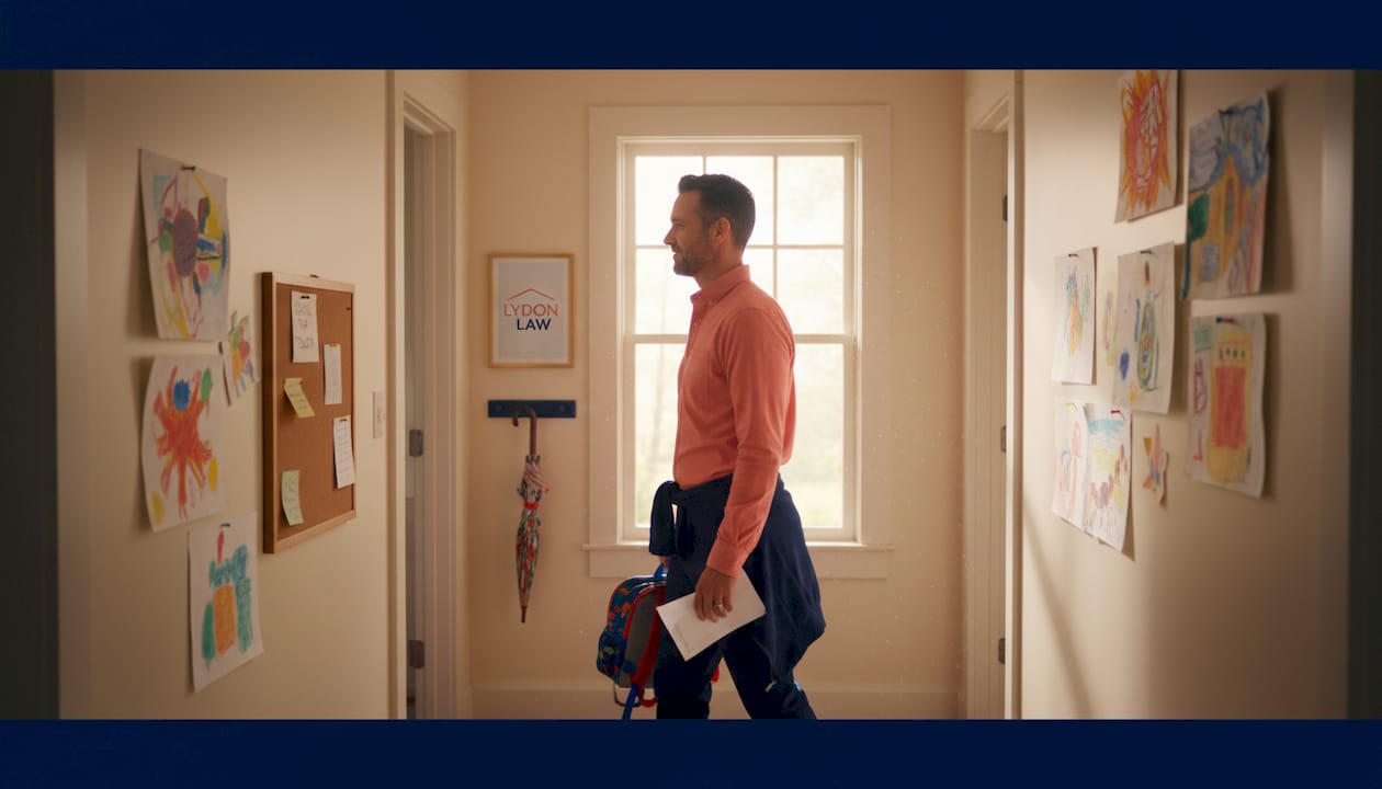 Father carries child’s backpack in hallway