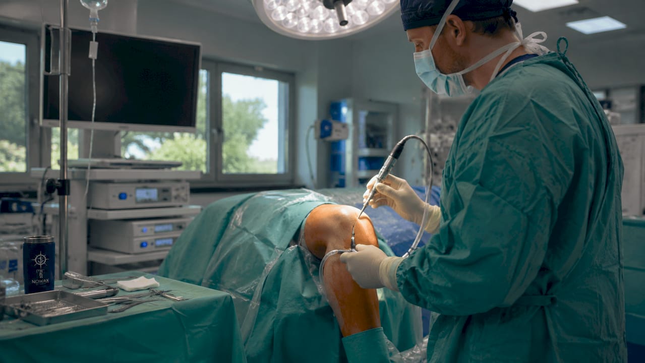 Surgeon performing arthroscopic knee surgery