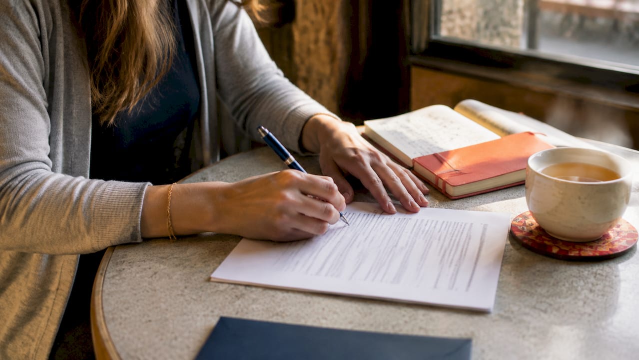 Hands signing legal documents close-up