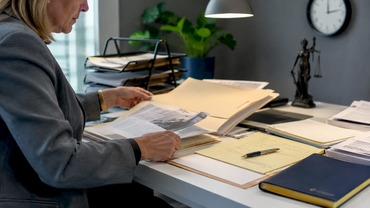 Hands sorting documents during magistrate hearing