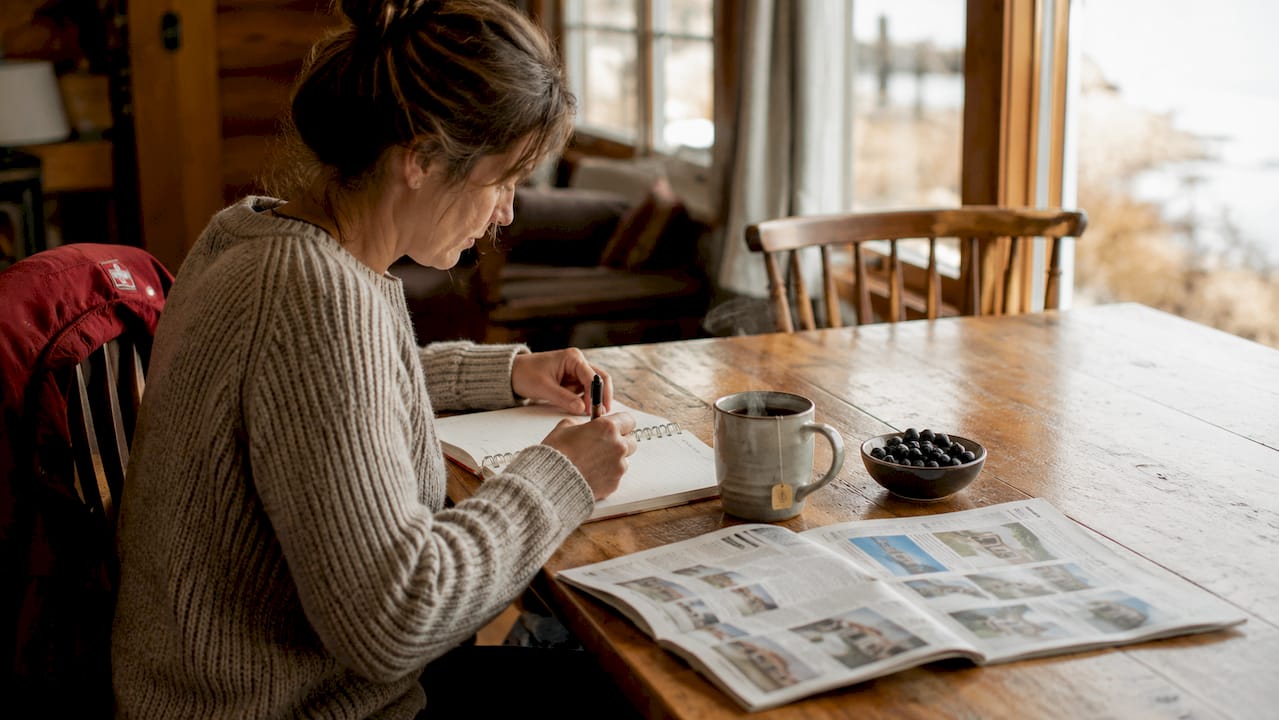 Kitchen table with newspaper and budgeting items