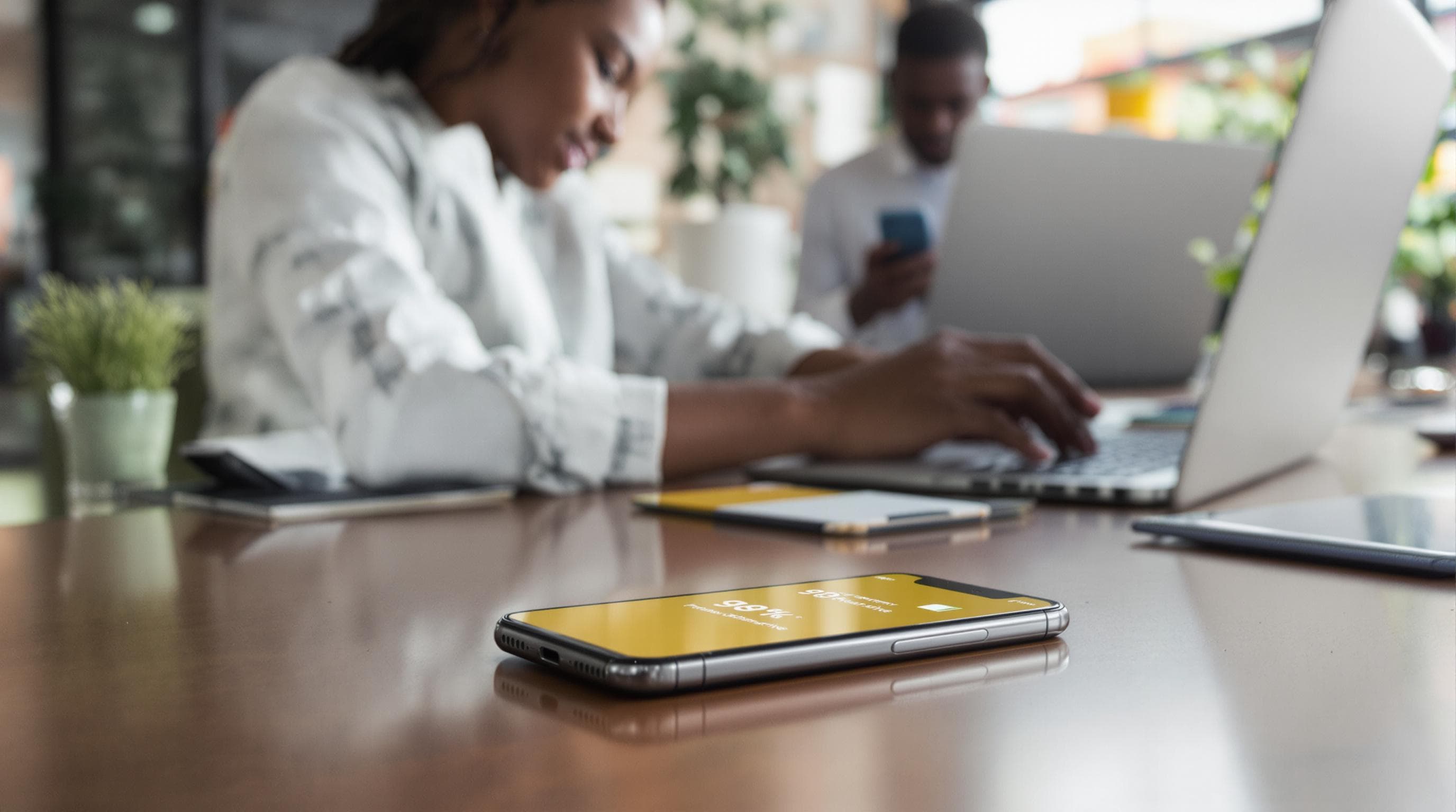 Tech professional’s smartphone with high battery and productivity message in office