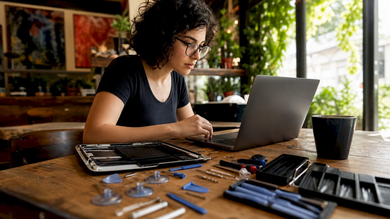 Woman following DIY iPad screen repair tutorial at desk