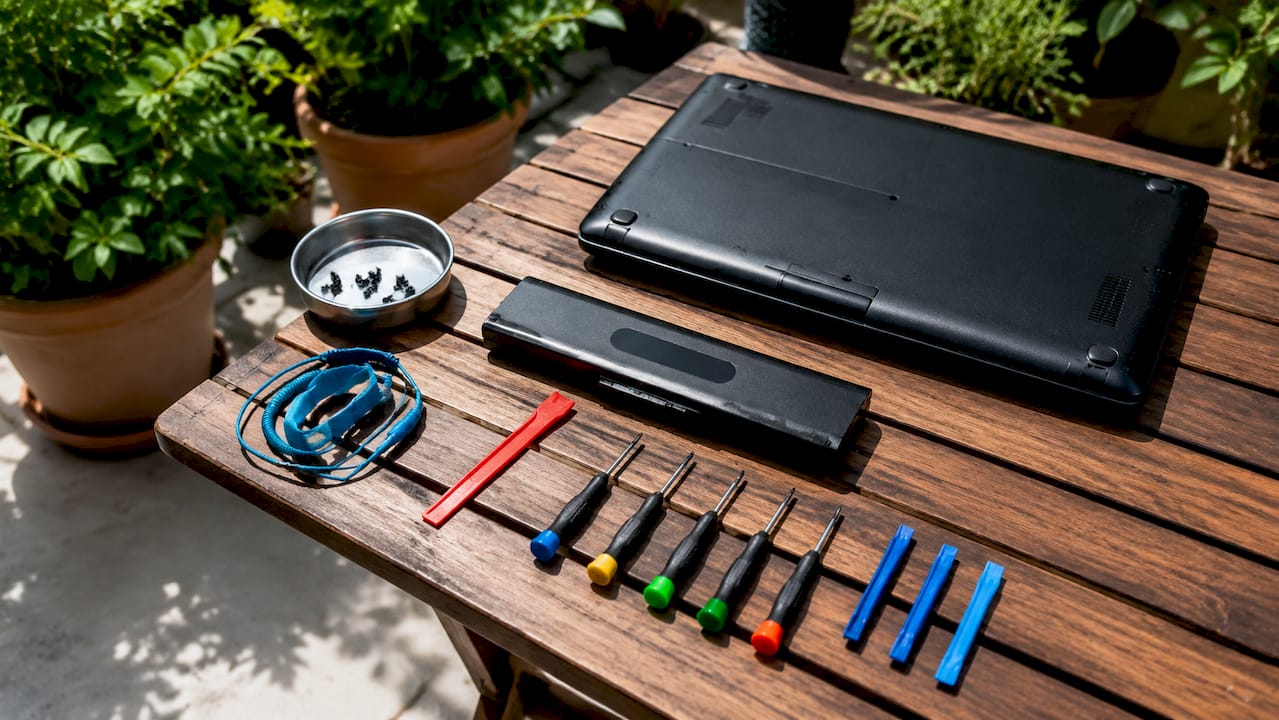 Close-up of laptop battery replacement tools on desk