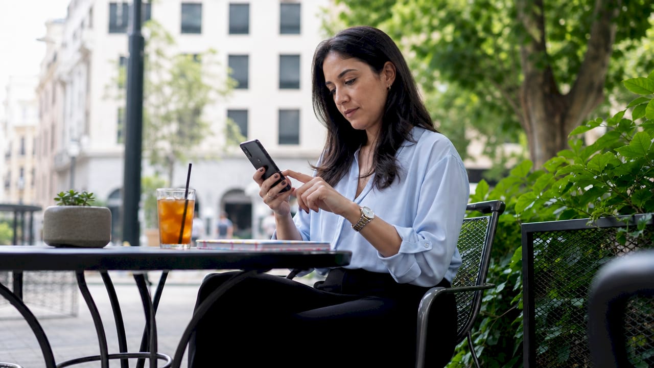 Woman checking Samsung model code in settings at café