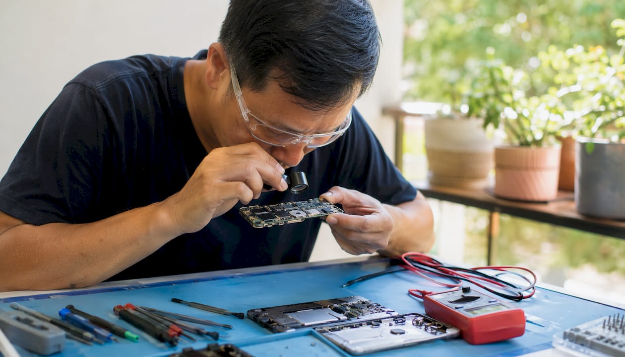 Technician inspecting smartphone motherboard