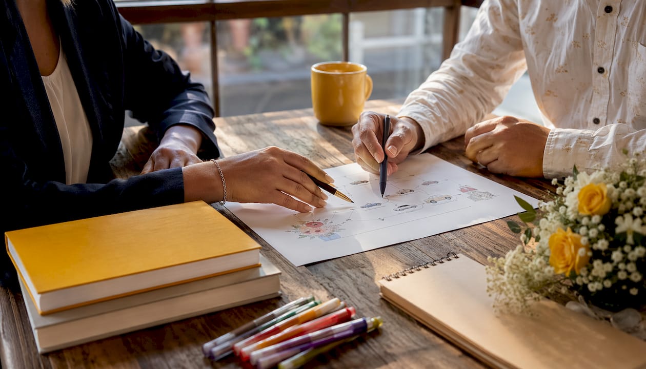 Hands arranging wedding shuttle itinerary documents