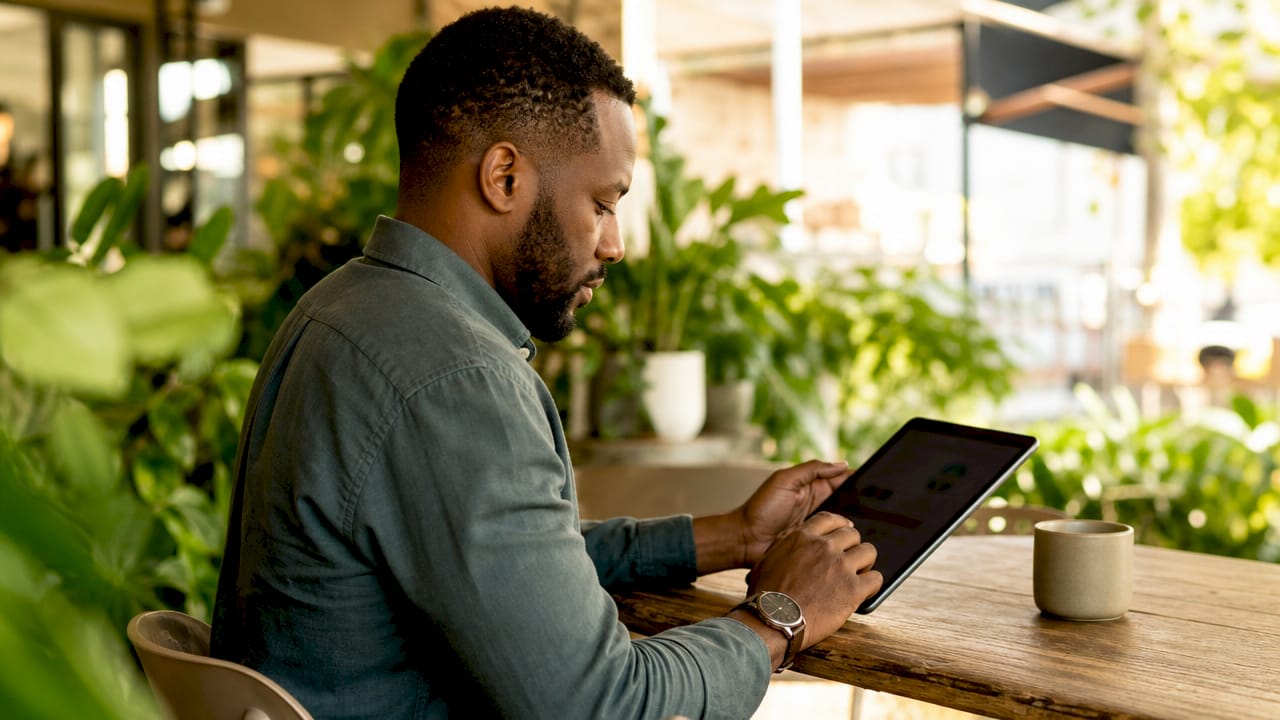Hands scrolling marketing data on tablet