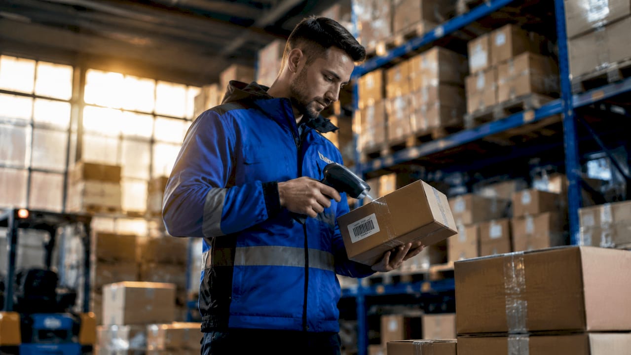 Courier scanning packages in warehouse loading bay