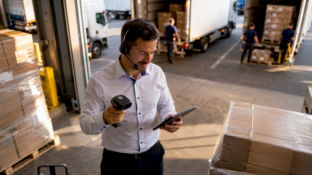 Logistics manager in active warehouse with parcels