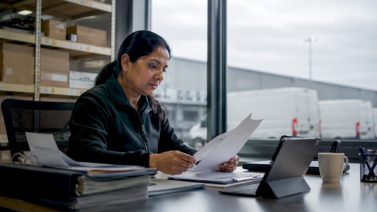 Logistics manager reviewing delivery manifests in warehouse office