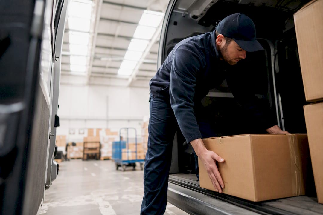 Courier loading sealed container into van