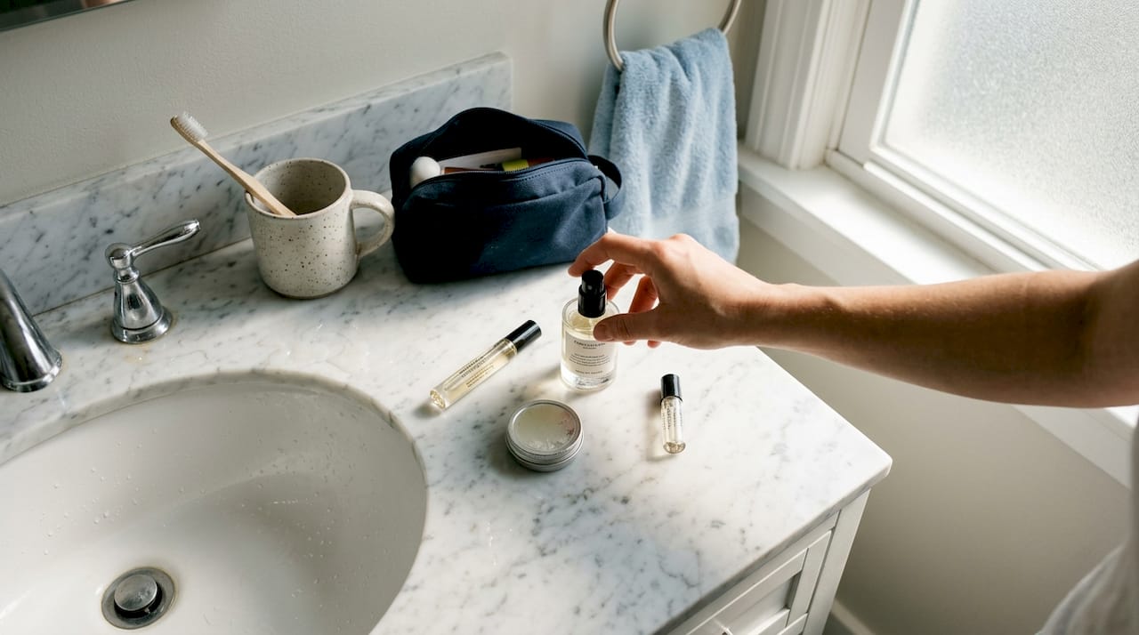 Different travel-size perfumes on bathroom counter