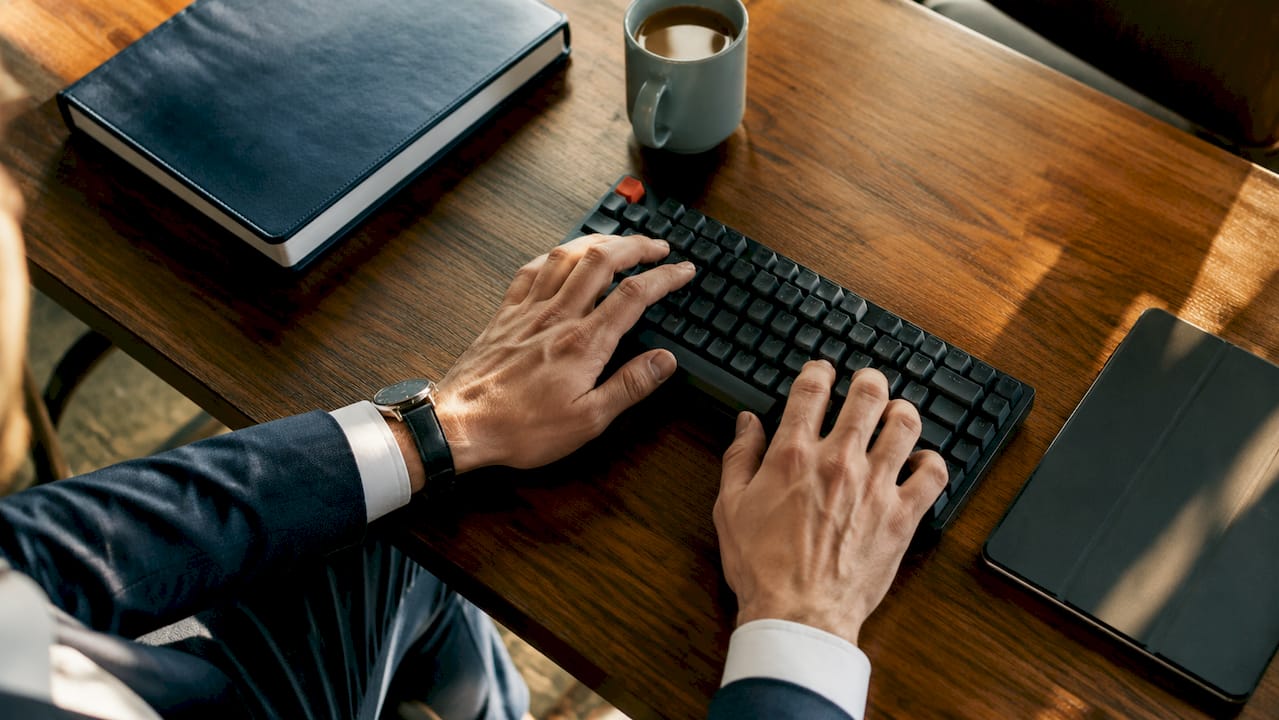 Hands typing compliance data on keyboard