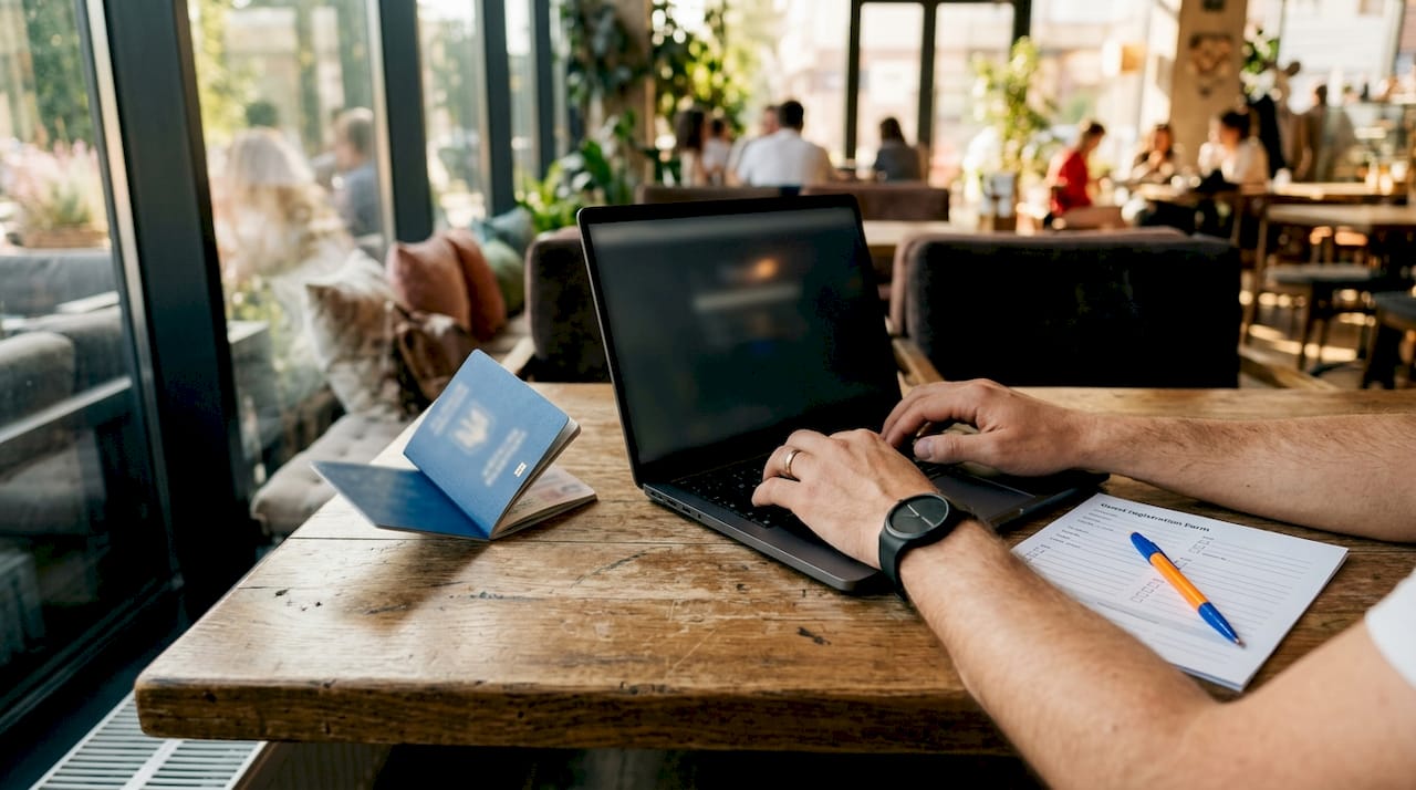 Hands entering guest data with passport at desk