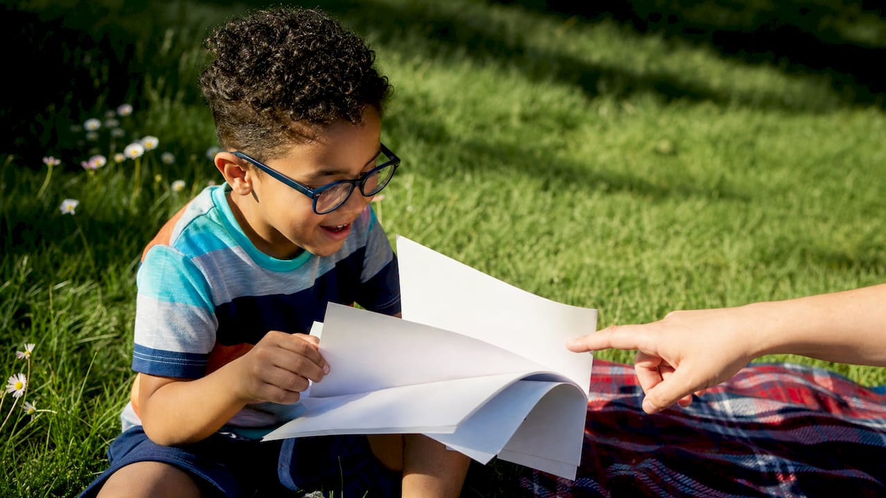 Child and adult reviewing Social Story booklet at table
