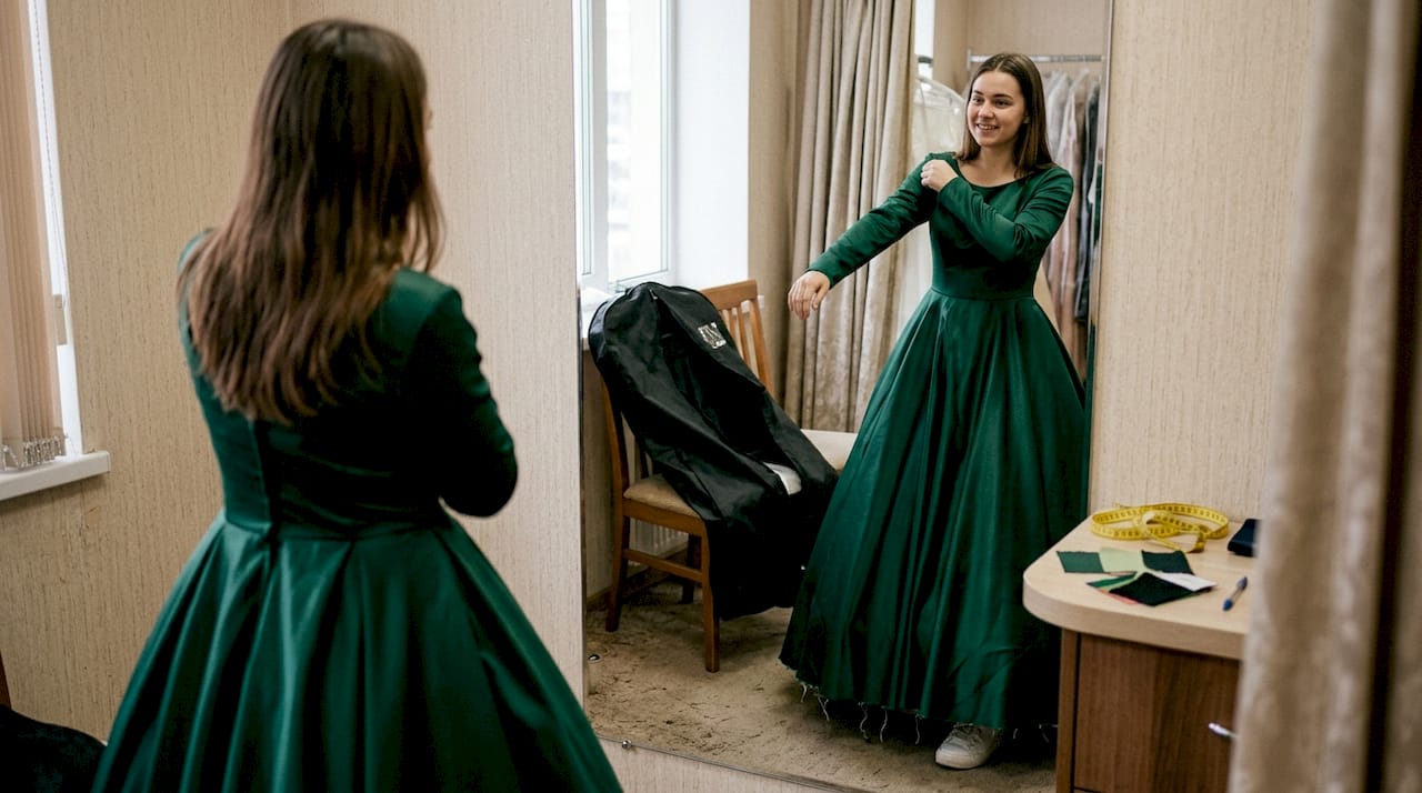 Woman adjusting ball gown in fitting room