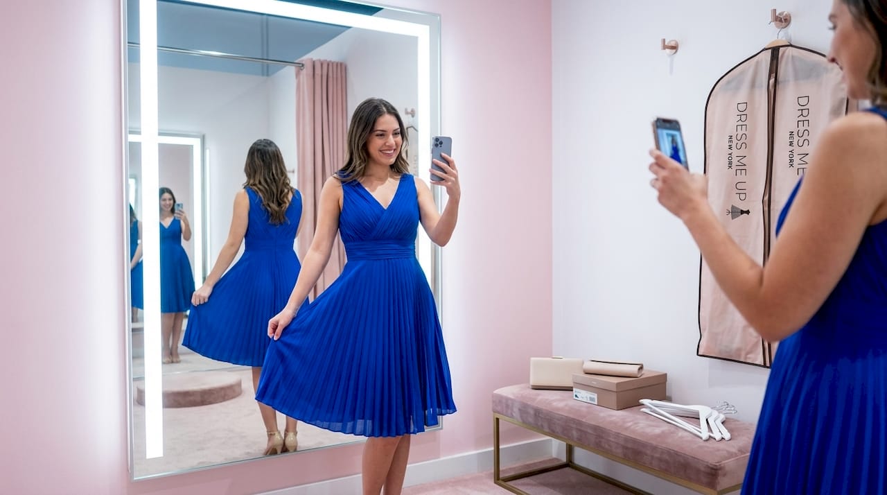 Woman adjusts cocktail dress in fitting room