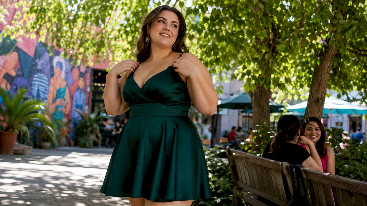 Plus size woman fitting short homecoming dress in boutique