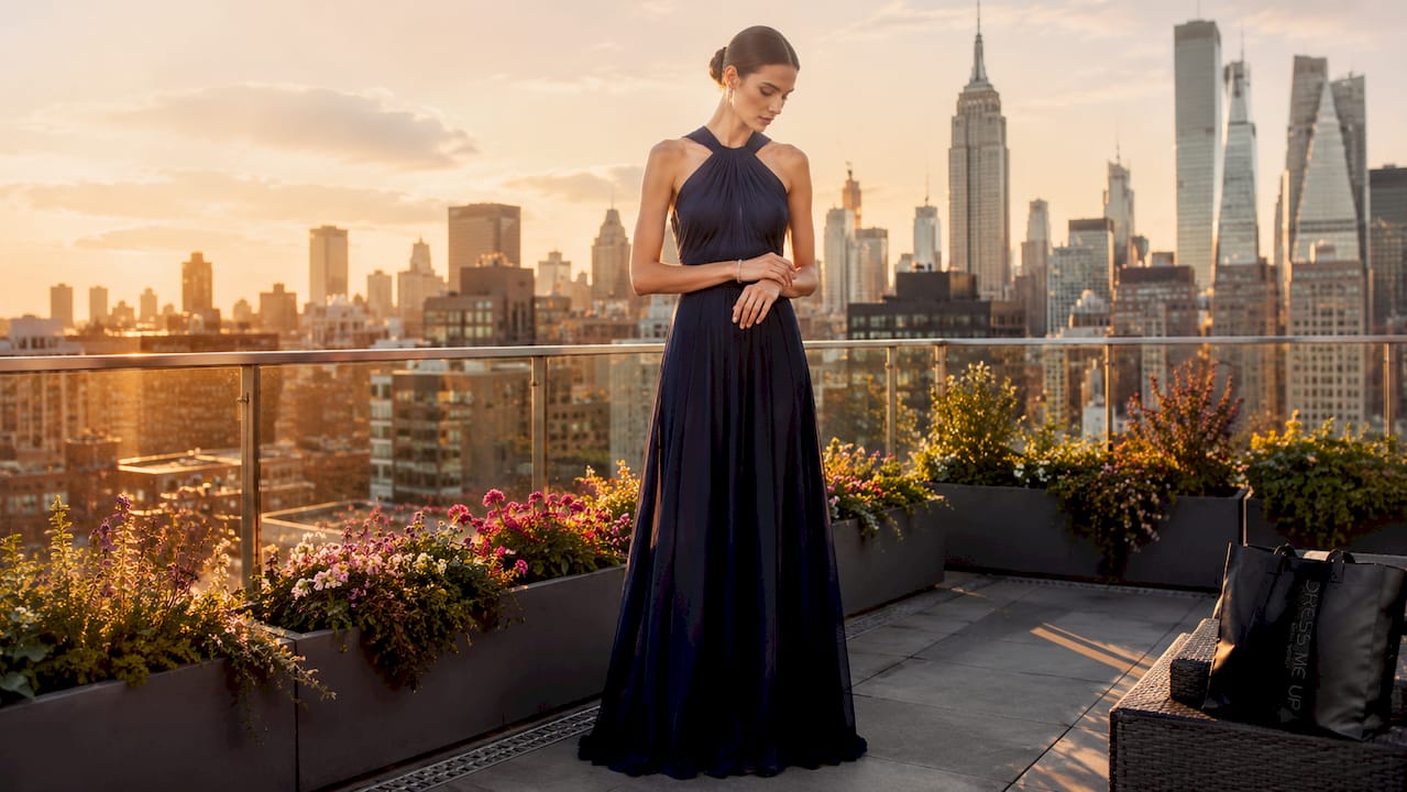 Tall woman modeling an elegant evening gown in ballroom