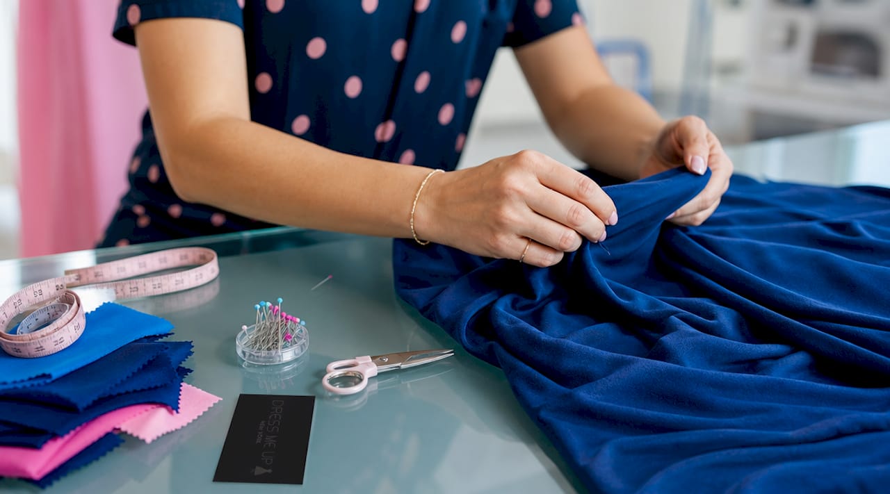 Tailor measuring stretch fabric for a dress