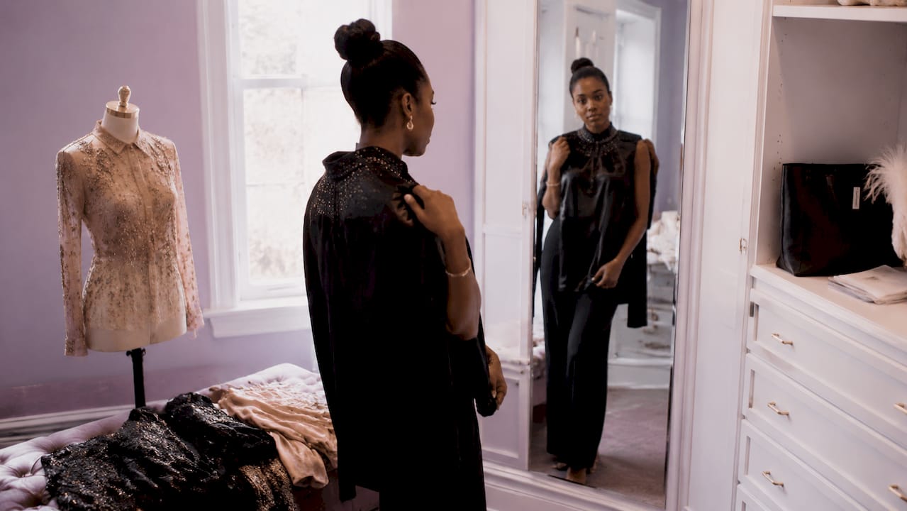Woman holding satin formal evening top in dressing room