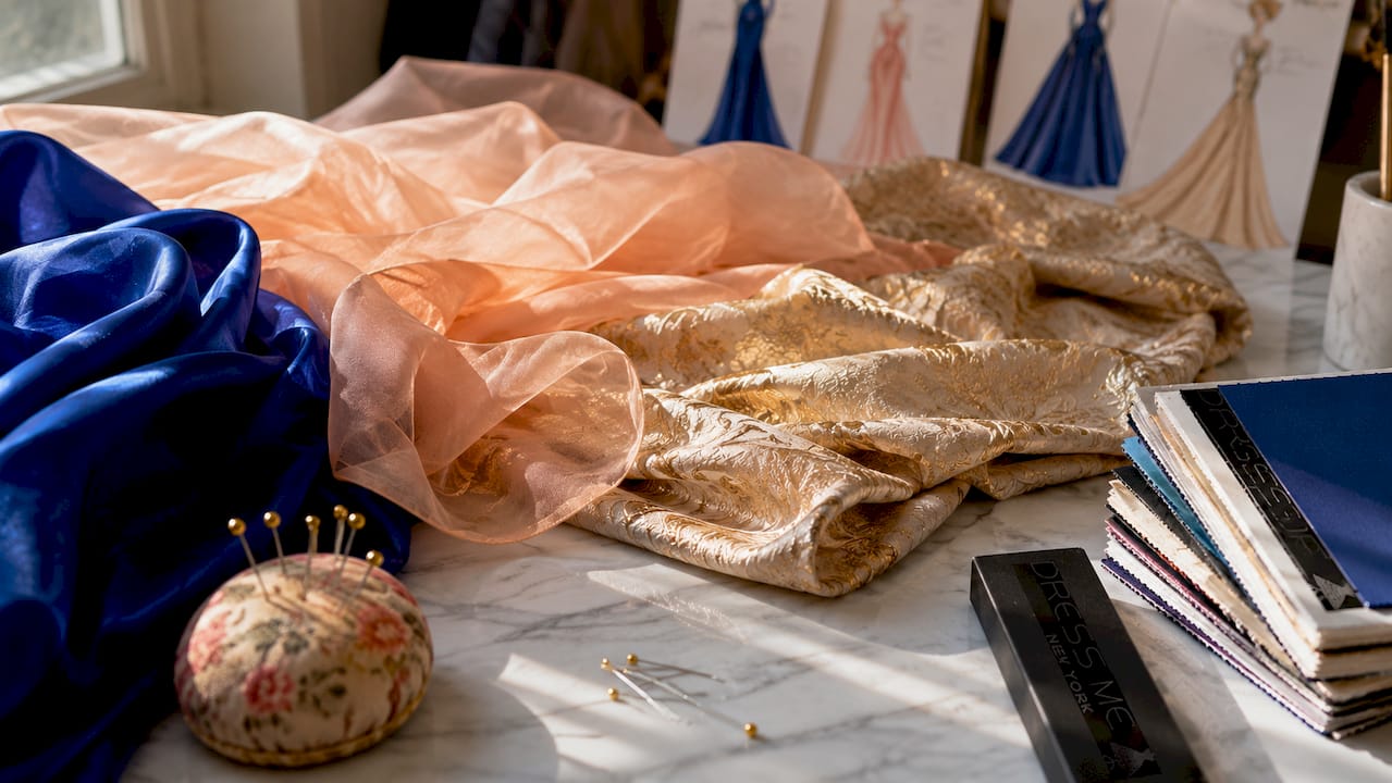 Close-up flat lay of formal gown fabrics and sewing tools