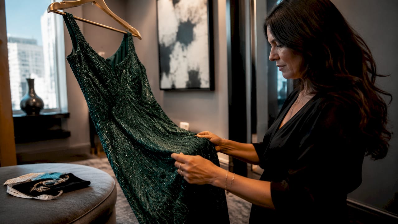 Hands inspecting stretch fabric on evening gown
