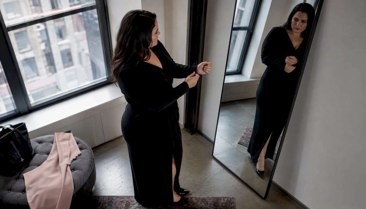 Plus size woman adjusting long-sleeve formal dress